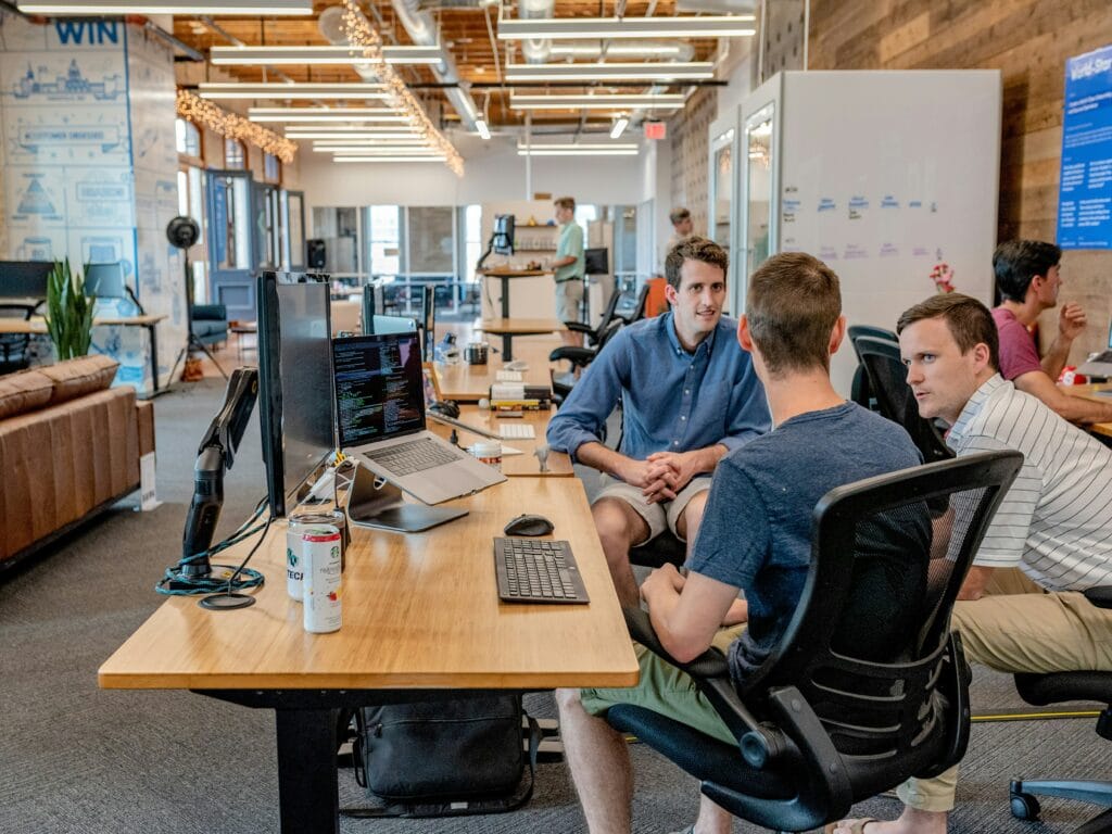 Employees collaborating in a modern open-plan office workspace.